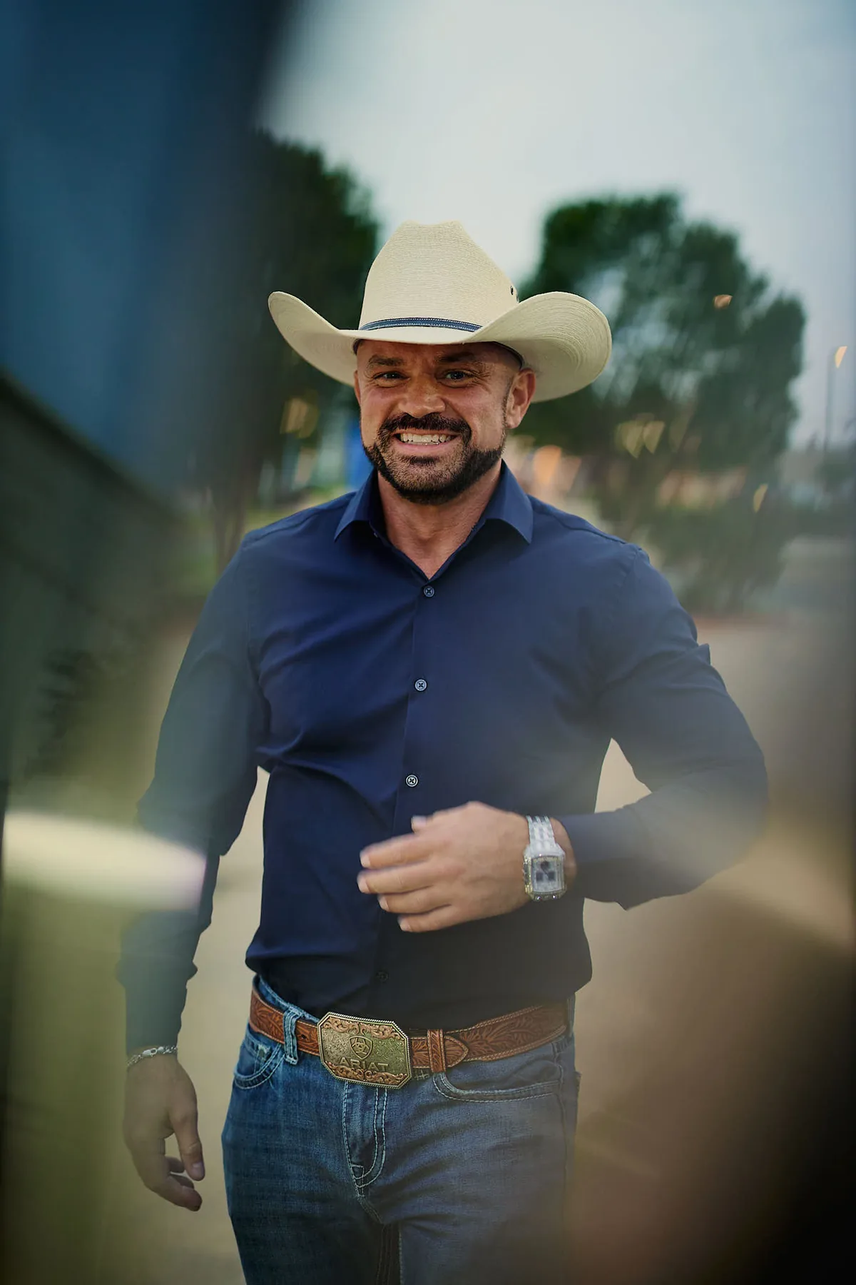 Man in a cowboy hat and navy shirt at golden hour, a Texas dating profile photo