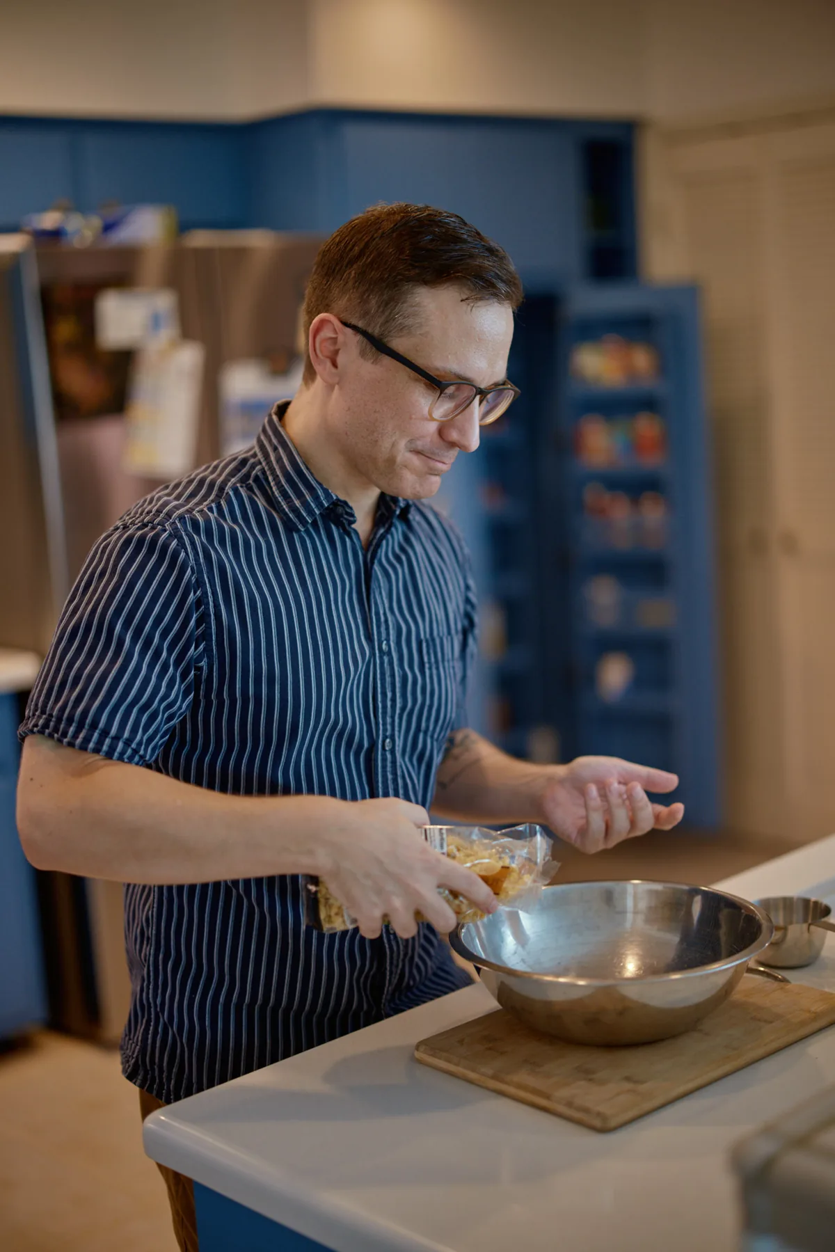 Man cooking at a kitchen counter with a mixing bowl, a lifestyle shot for a dating profile