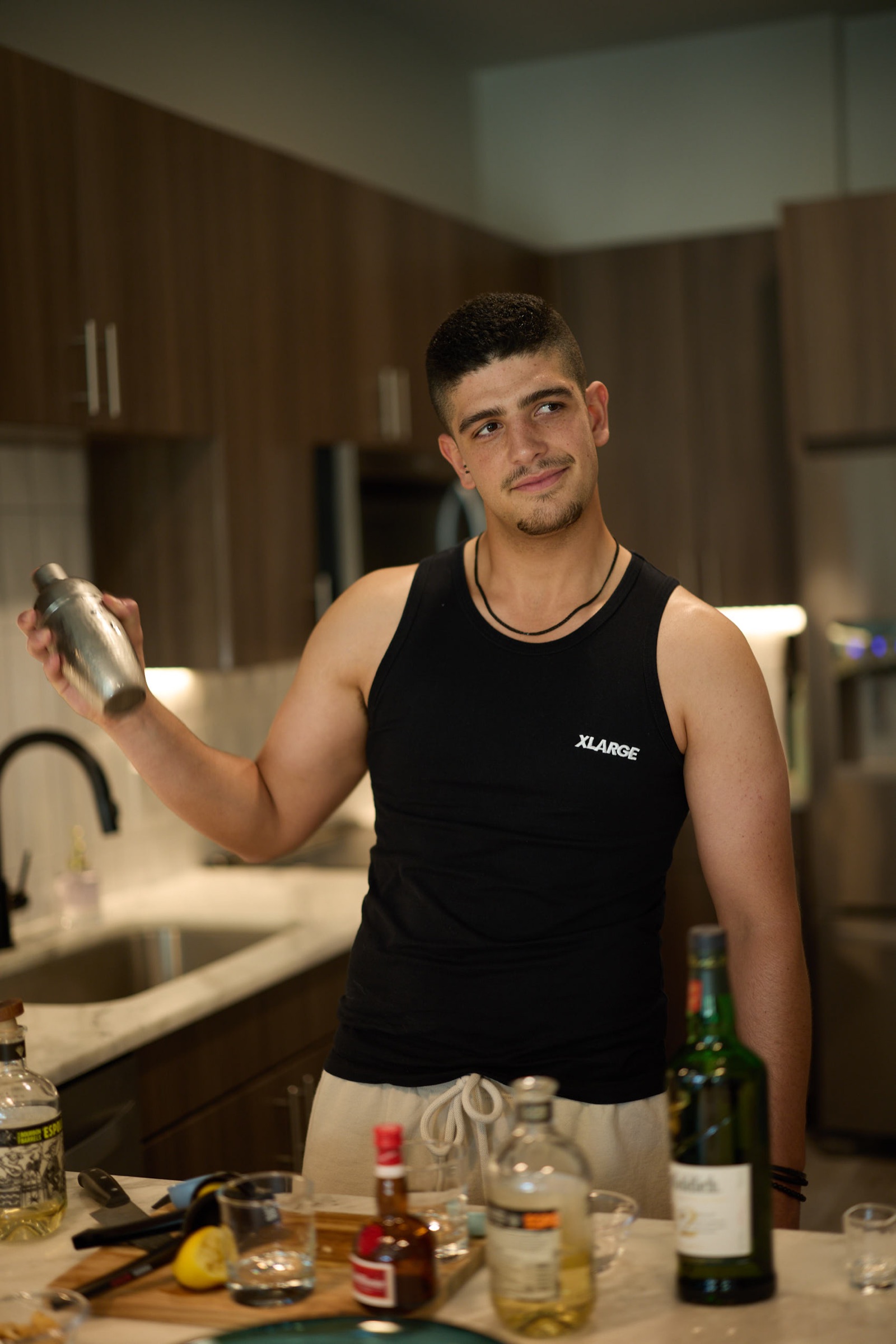Man making a cocktail in a kitchen during a dating profile photography session