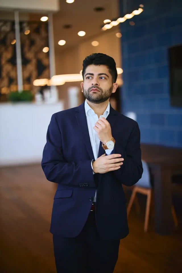 Man in a navy suit at an upscale venue, a confident lifestyle dating profile photo by Austin photographer Eli Samuel